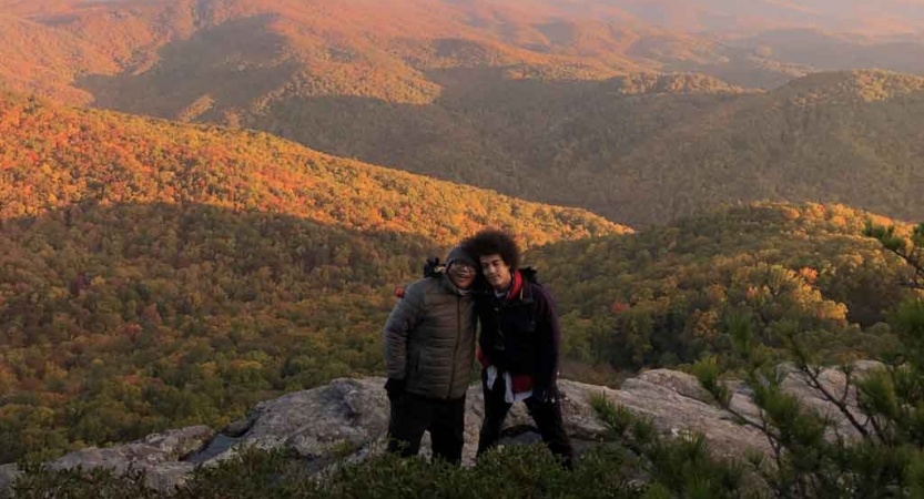 two gap year students smile for a photo on an overlook of the blue ridge mountains 